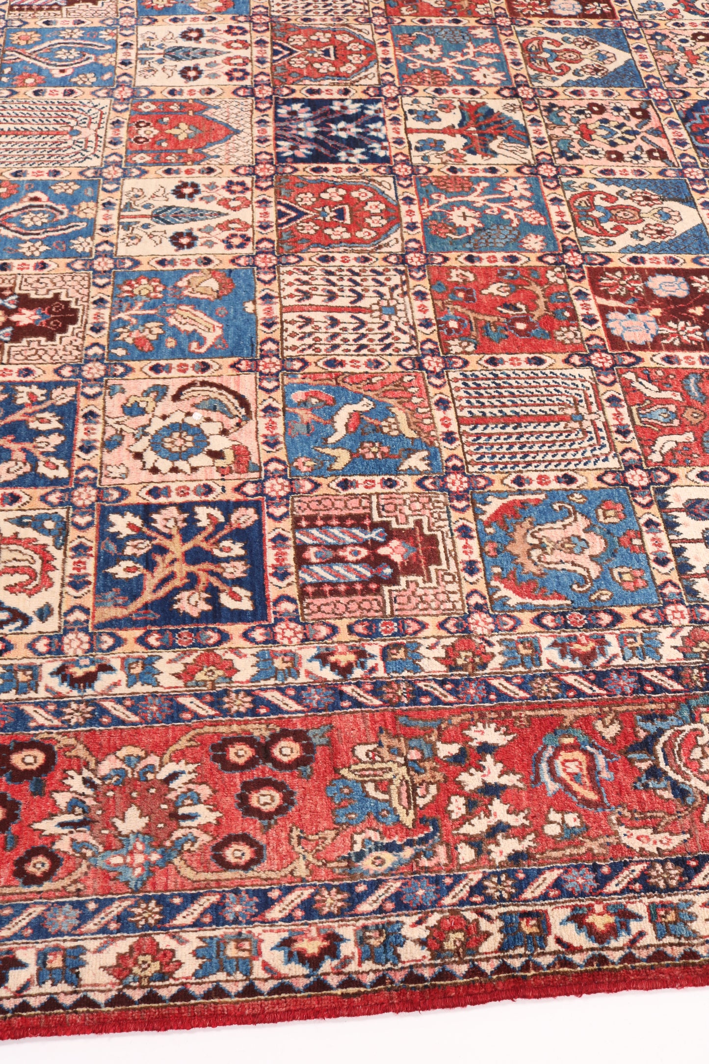 Close-up of a patterned rug with intricate designs in red, blue, and beige.