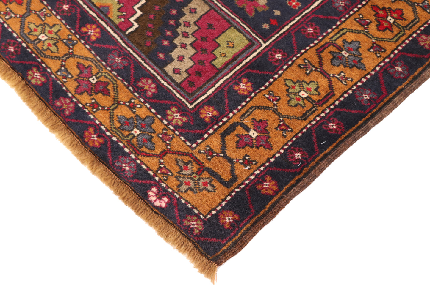 Close-up of a patterned rug corner with intricate designs.