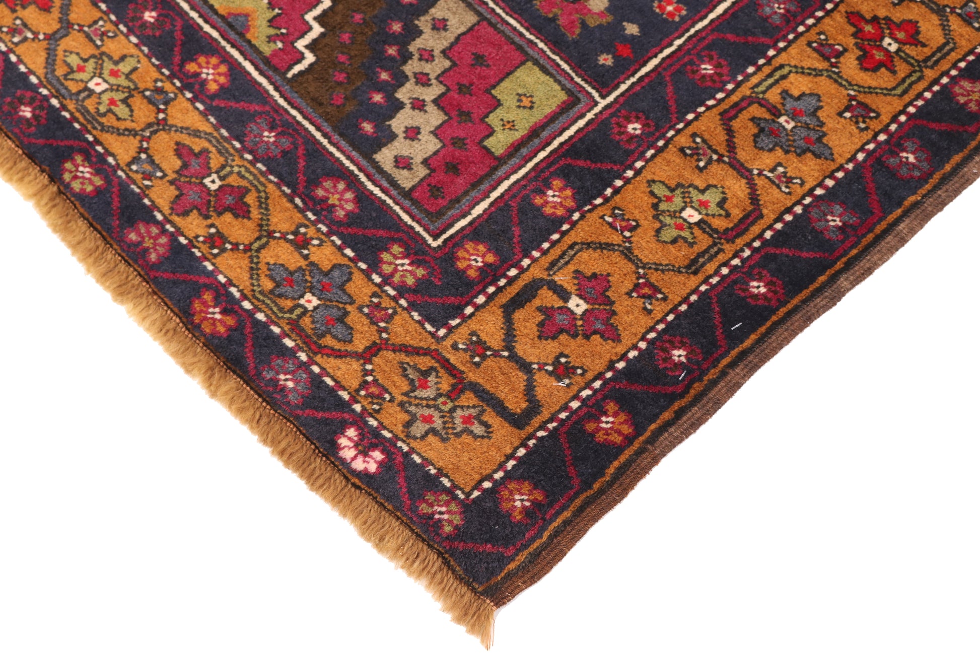 Close-up of a patterned rug corner with intricate designs.