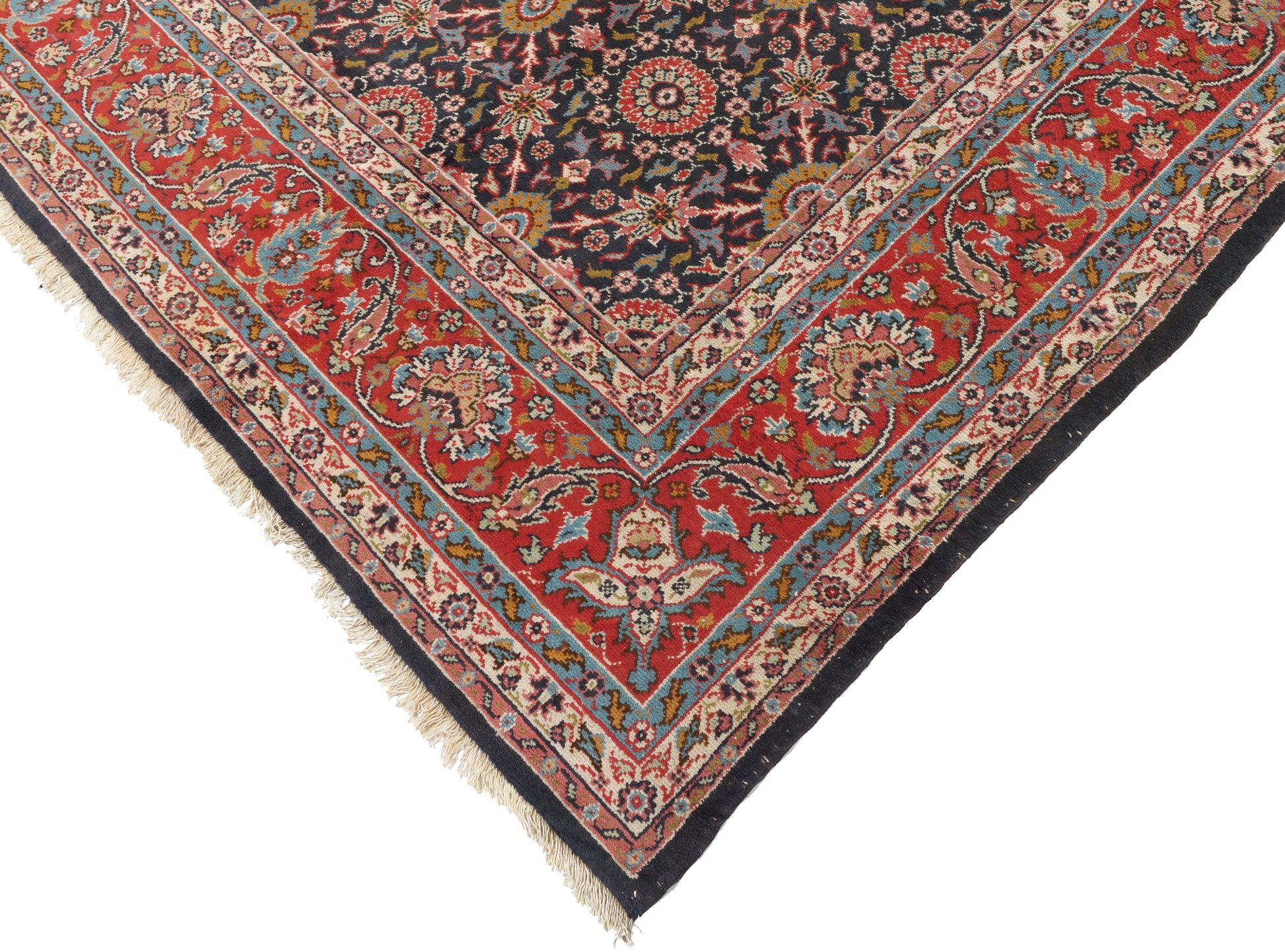 Corner of a colorful patterned rug with intricate designs on a white background