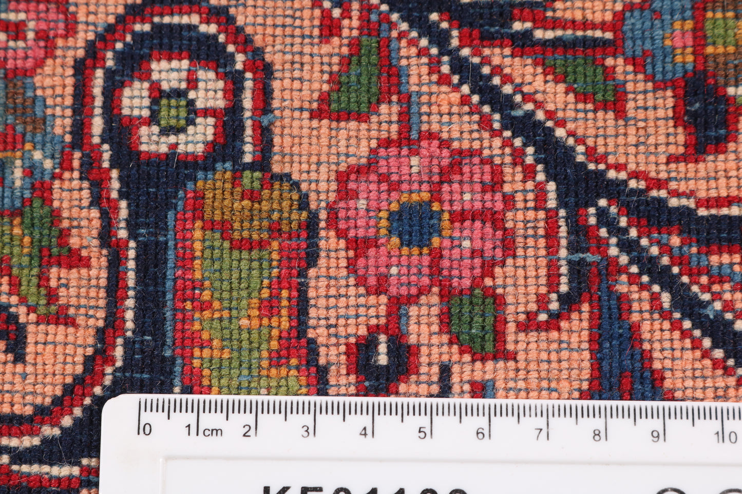 Close-up of a colorful patterned fabric with a ruler at the bottom for scale.