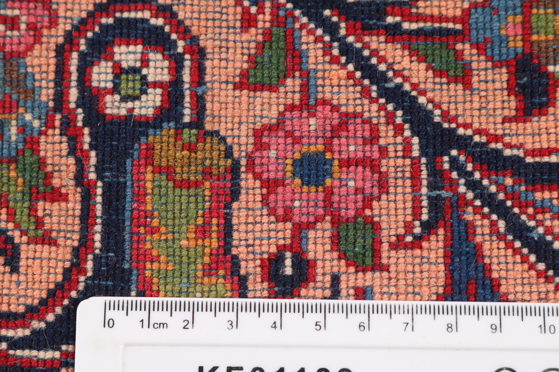 Close-up of a colorful patterned fabric with a ruler at the bottom for scale.