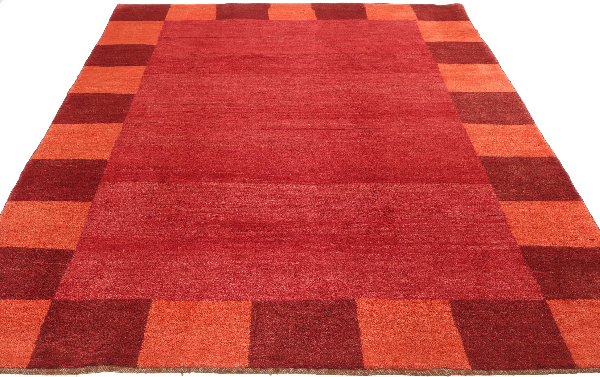 Rectangular red and orange checkered rug on a white background