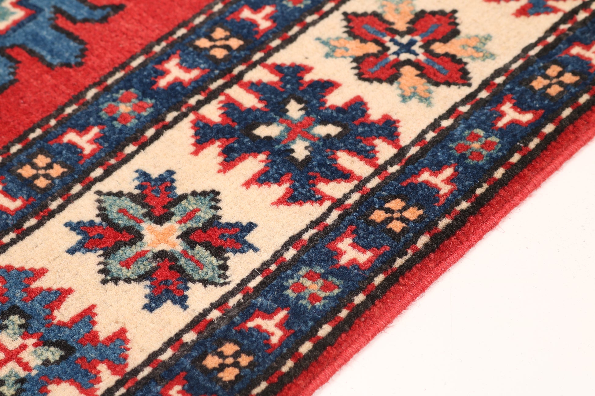Close-up of a patterned rug with red, blue, and beige colors.