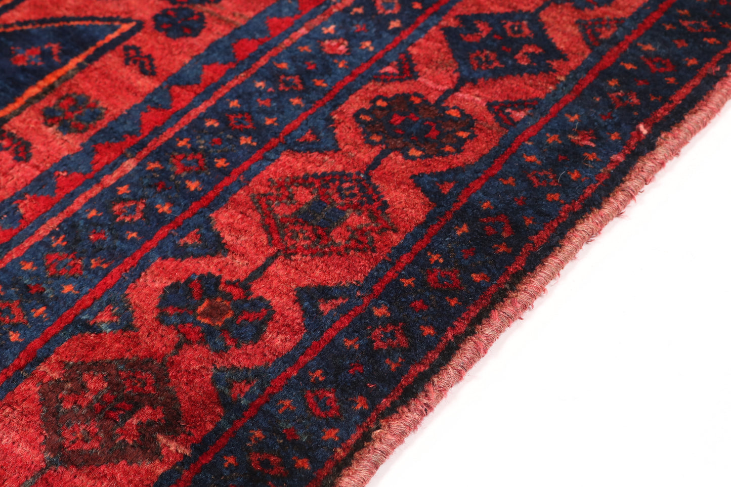 Close-up of a red and blue patterned rug on a white background