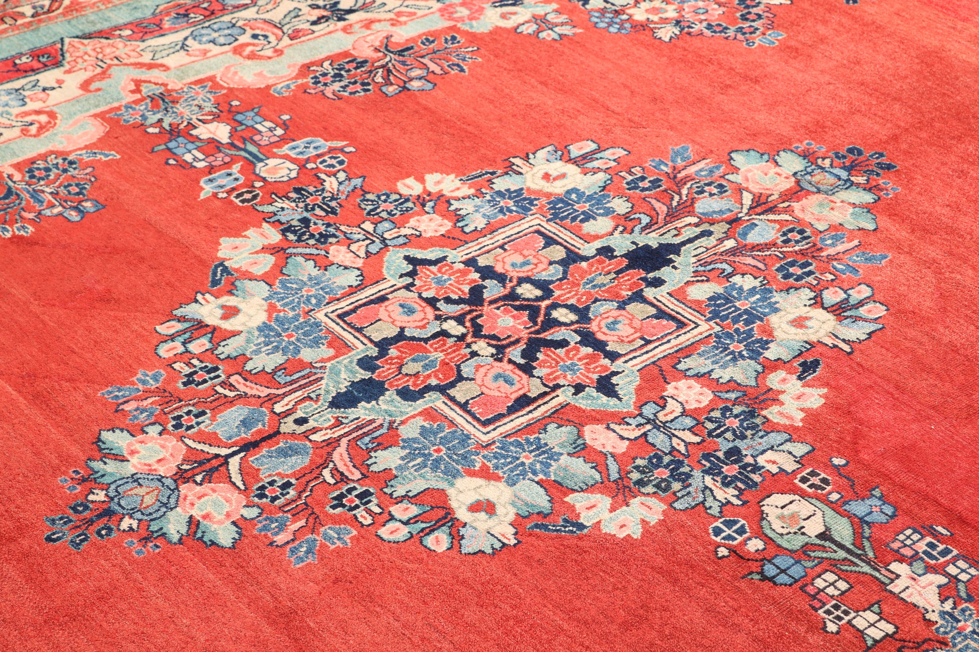 Close-up of a floral patterned rug with vibrant colors on a red background