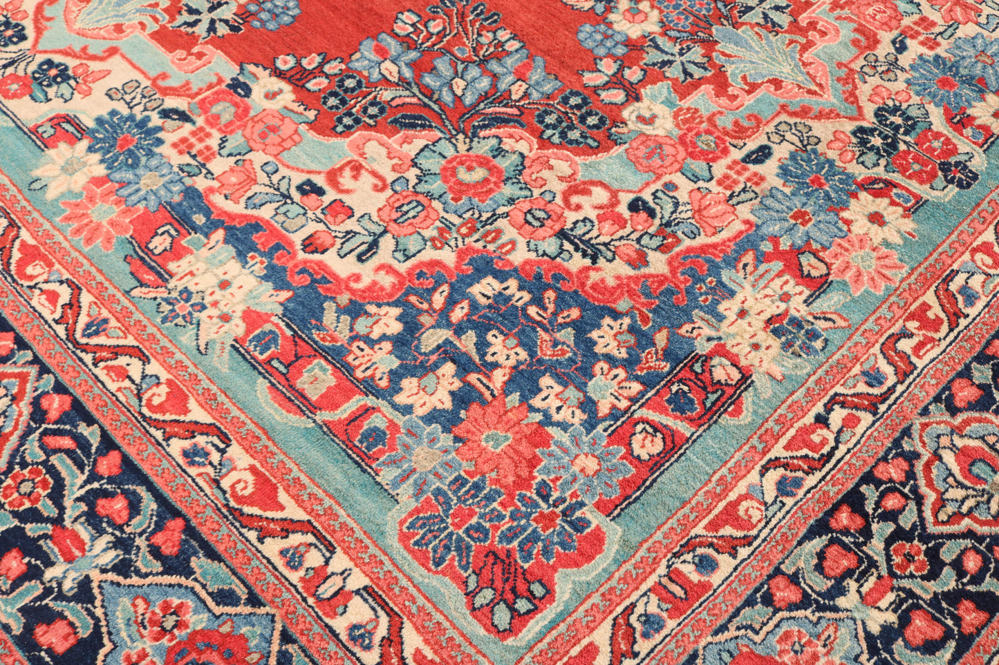 Close-up of a patterned rug with red, blue, and beige colors.