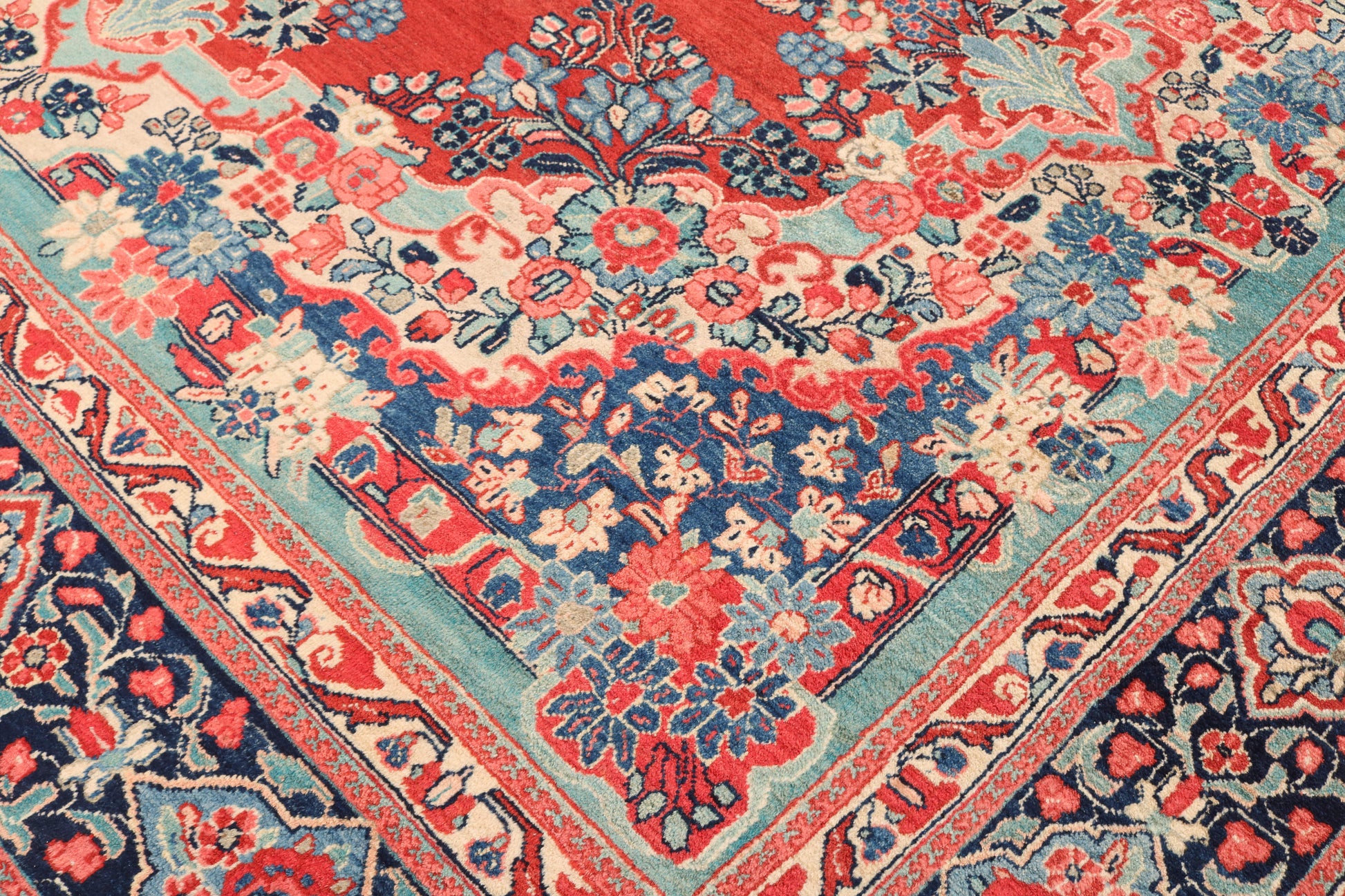 Close-up of a patterned rug with red, blue, and beige colors.