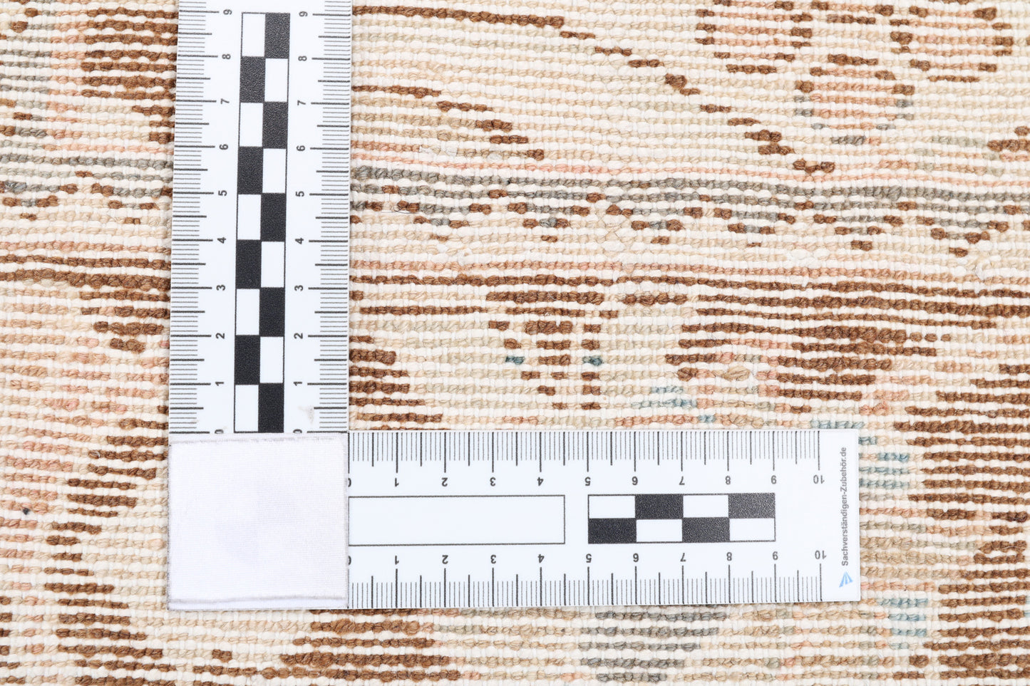 A ruler showing the weave and authentic rug for hire.