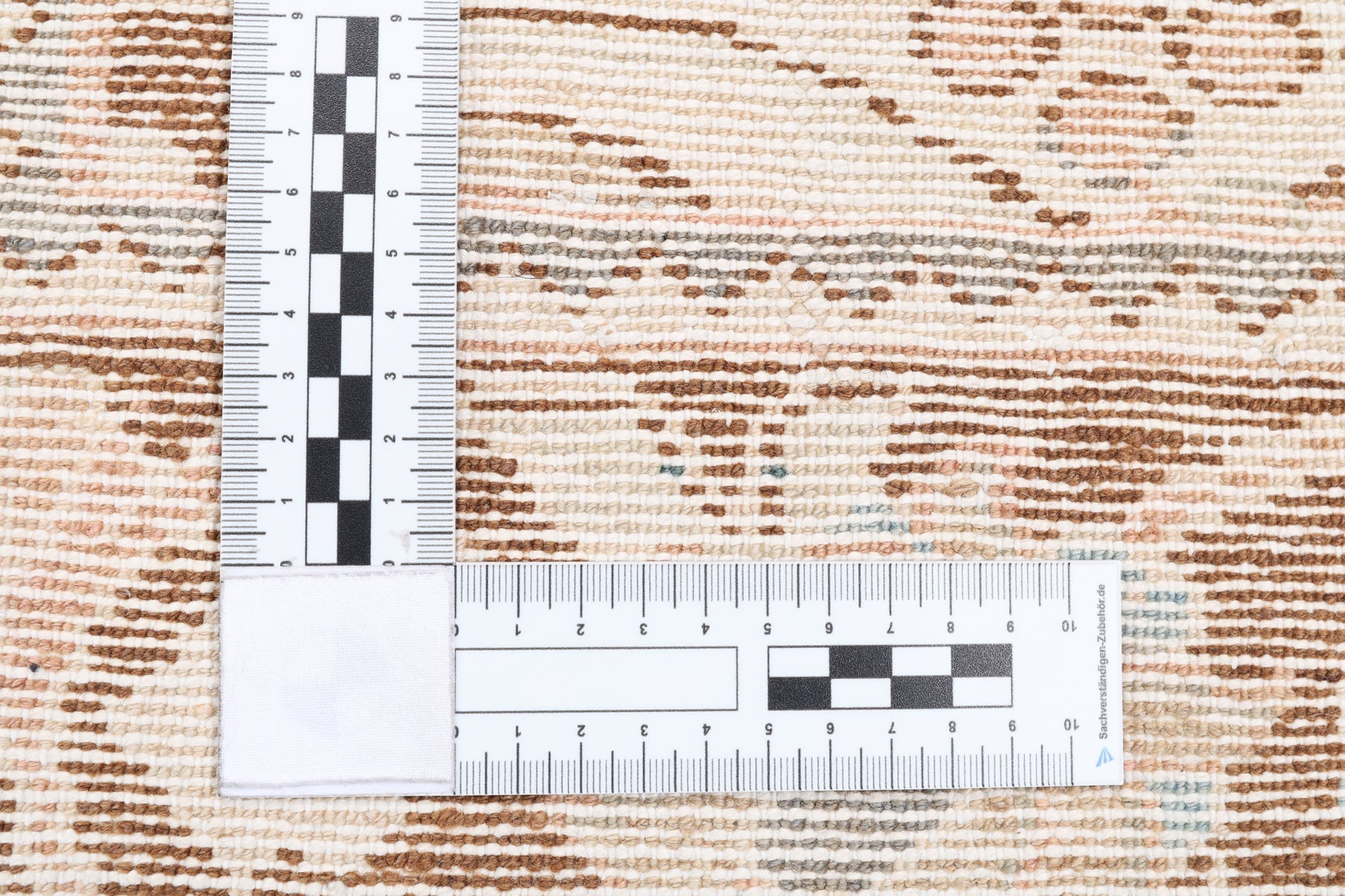 A ruler showing the weave and authentic rug for hire.