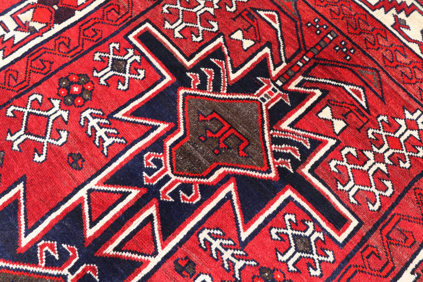 Close-up of a red and blue patterned fabric with star-like shapes and geometric designs.