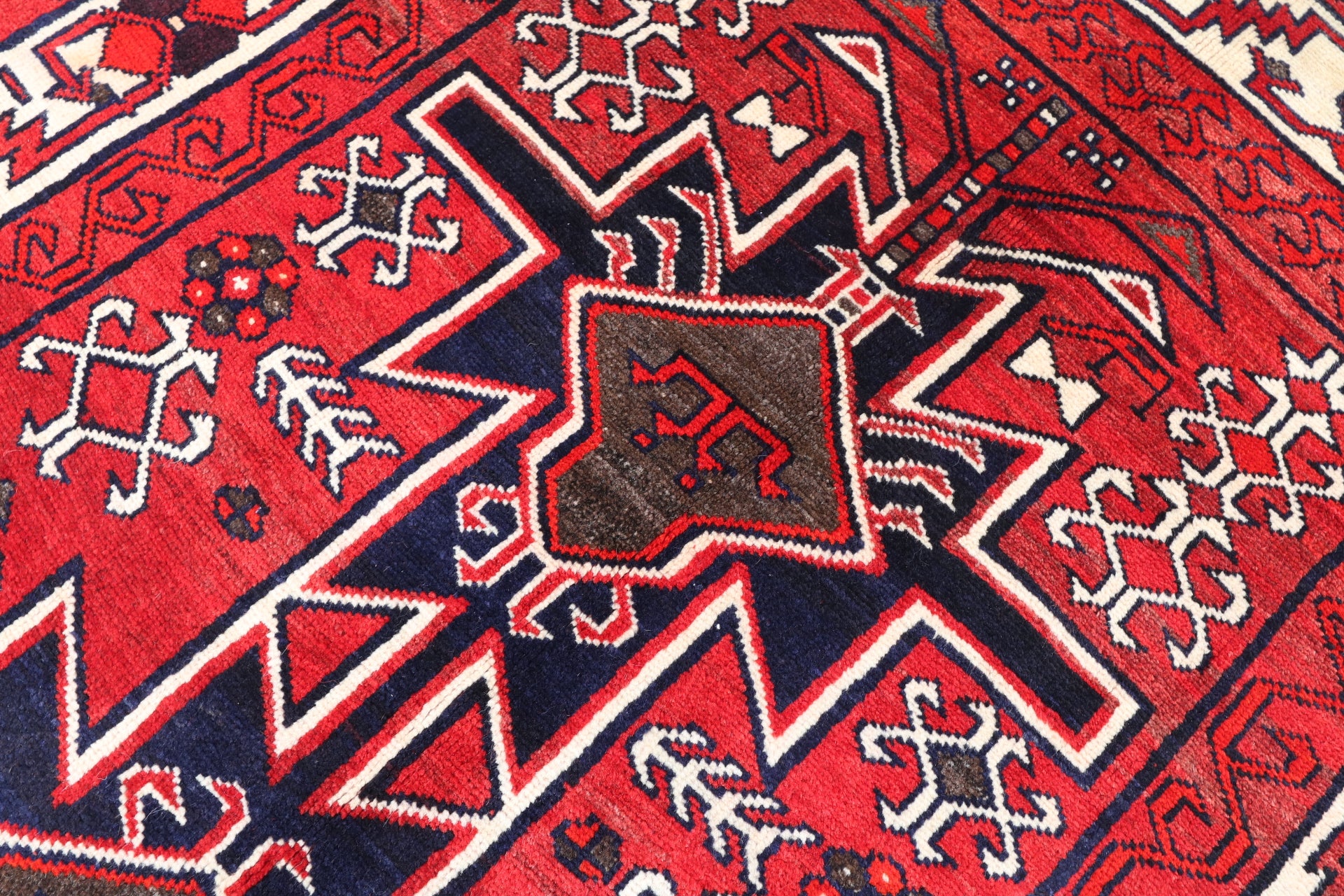 Close-up of a red and blue patterned fabric with star-like shapes and geometric designs.