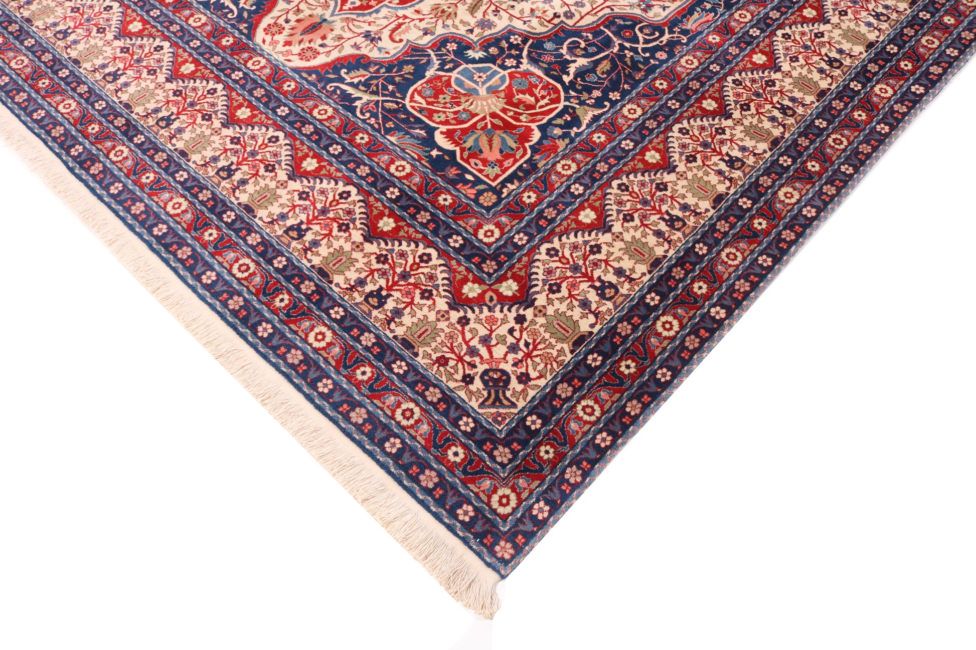 Corner of a patterned rug with red, blue, and beige colors on a white background