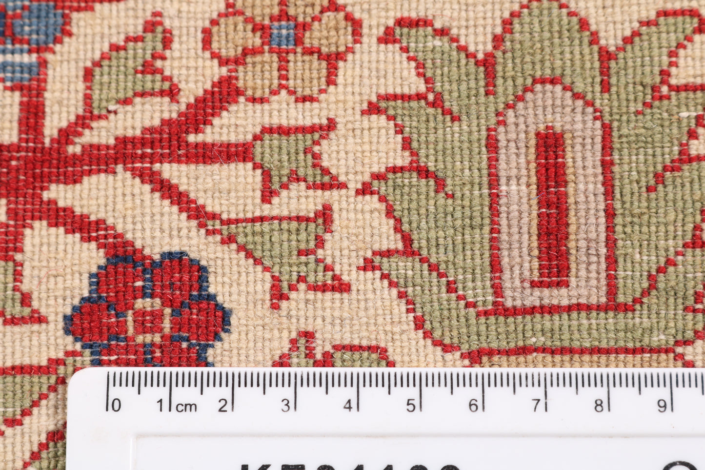 Close-up of a patterned rug with a ruler for scale