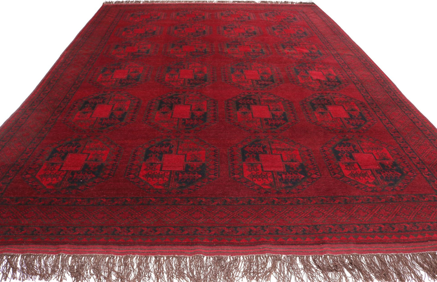 Red patterned rug with fringes on a white background