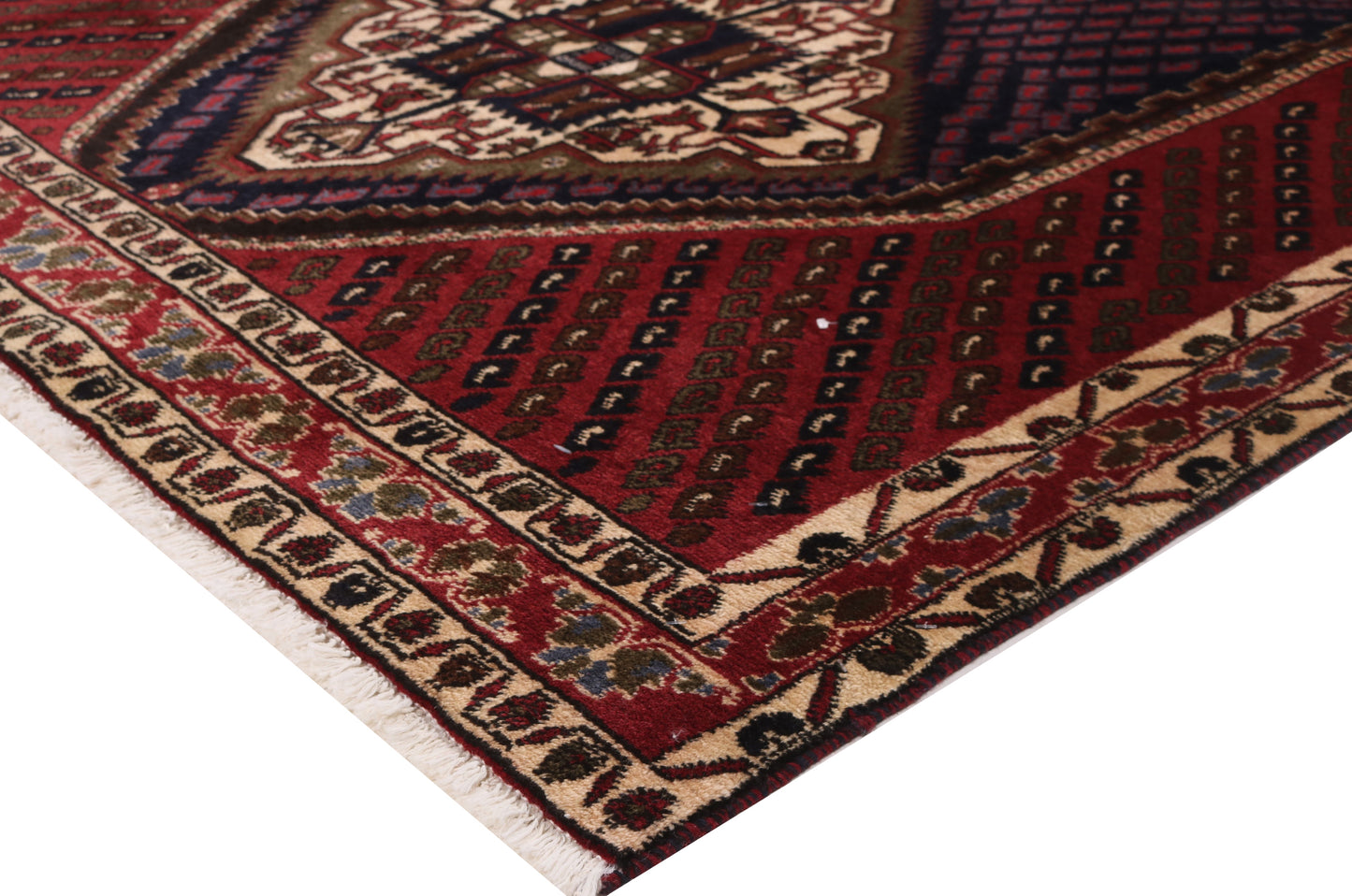 Close-up of a patterned rug with red, brown, and beige colors.