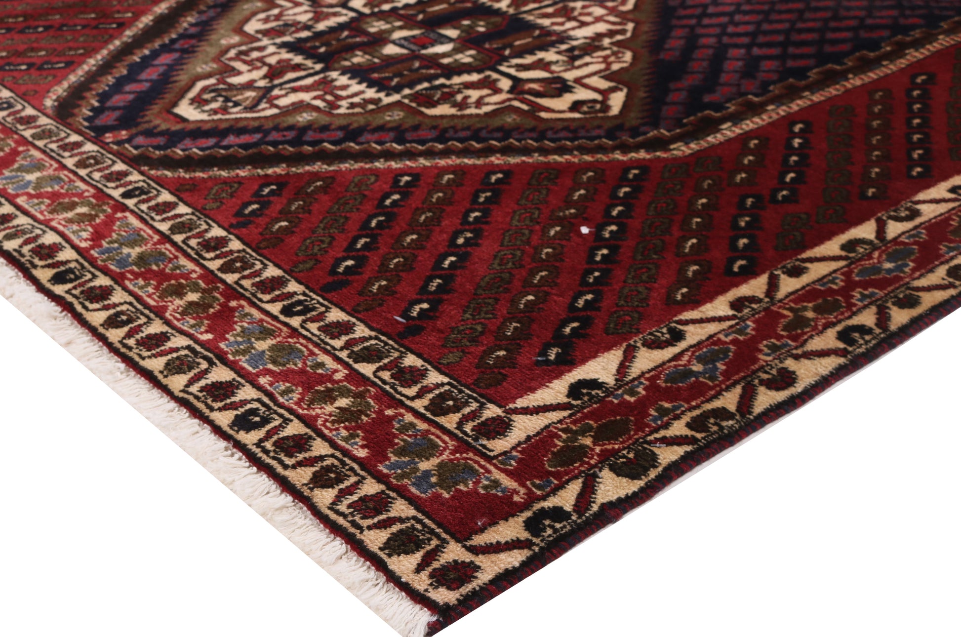 Close-up of a patterned rug with red, brown, and beige colors.