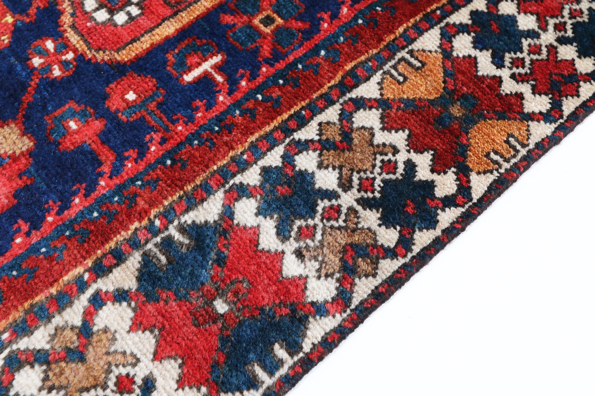 Close-up of a patterned rug with red, blue, and beige colors.