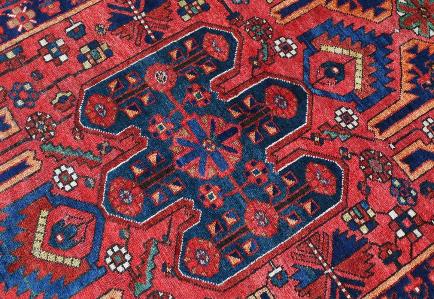 Close-up of a red and blue patterned rug with geometric designs
