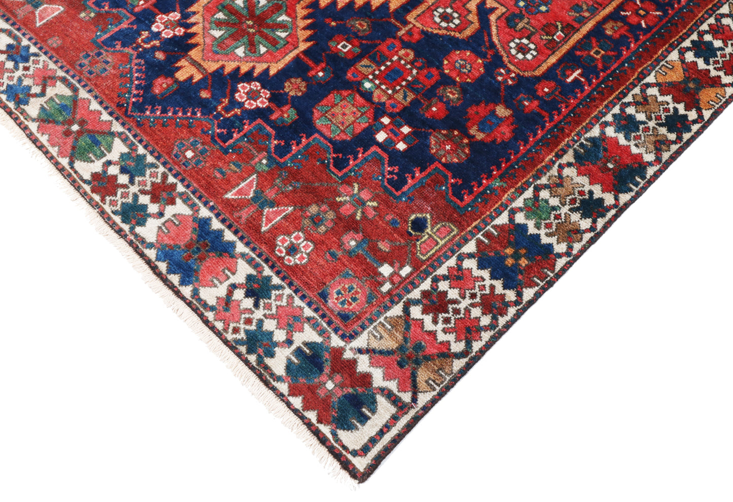 Close-up of a colorful patterned rug with red, blue, and multicolor design.