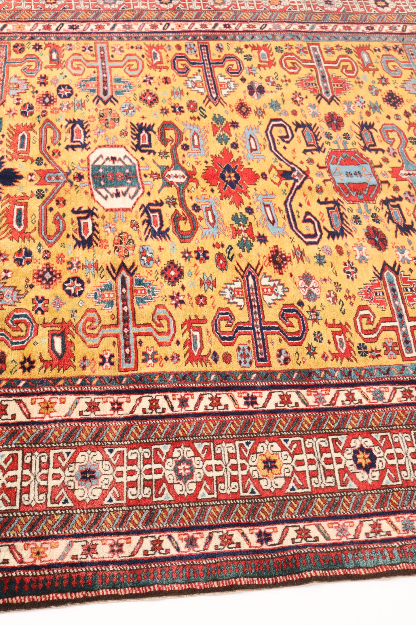 Close-up of a colorful patterned rug with intricate designs on a yellow background.
