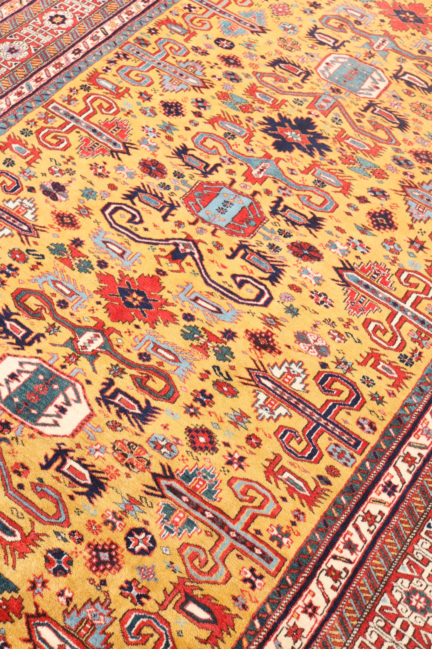 Close-up of a colorful patterned rug with intricate designs on a yellow background.